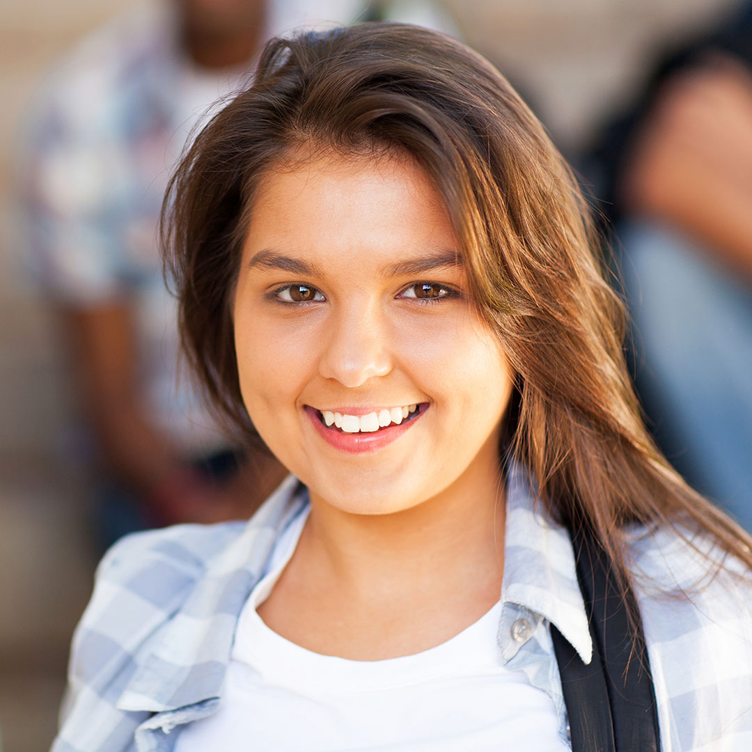 teen foster child smiling towards camera wearing backpack