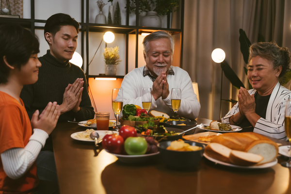Asian family praying over meal